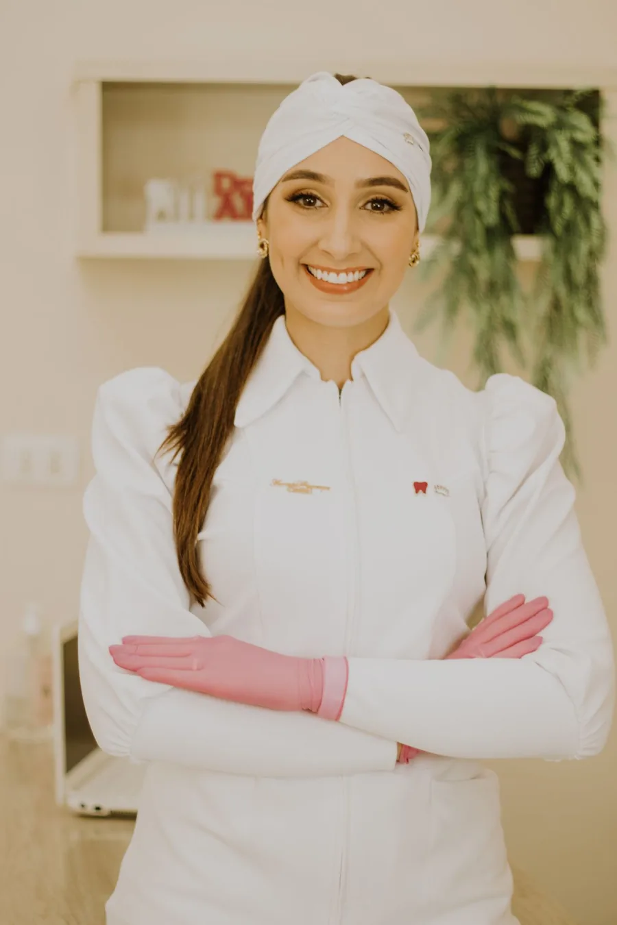 Photograph of a dentist in a white coat and gloves inside a dental practice
